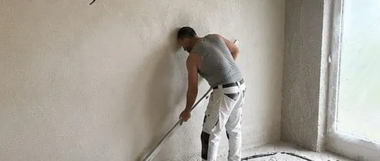 Abziehen der frisch verputzten Wandfläche
