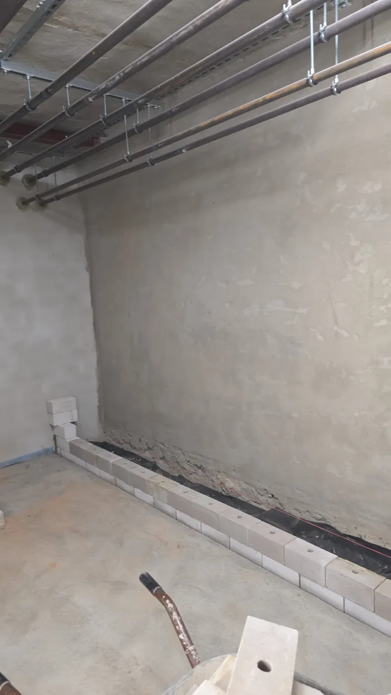 Fertig verputzte Kellerwand mit sauberen Anschlüssen